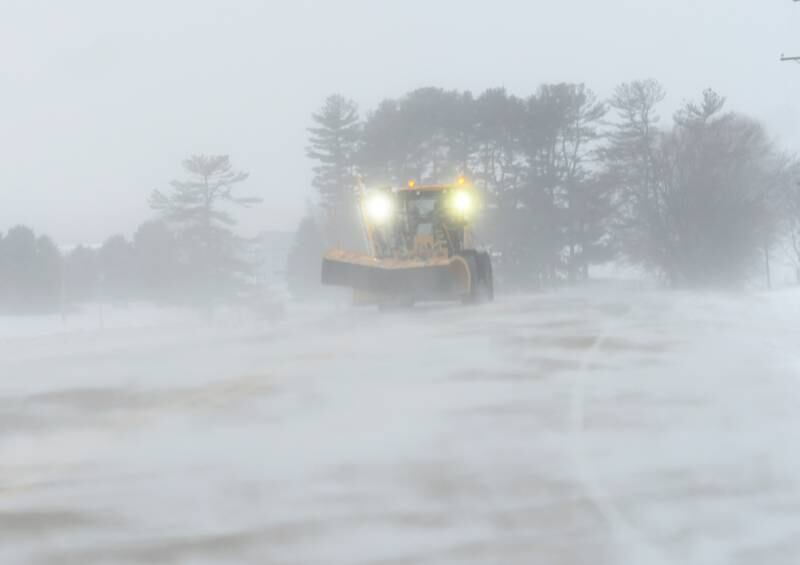 An Ogle County snow plow can barely be seen as it heads east on Pines Road late Friday afternoon. Crews worked throughout the day trying to clear roads after winds and blowing snow made many roads impassable prompting officials to strongly advise motorists not to venture out during the winter storm..