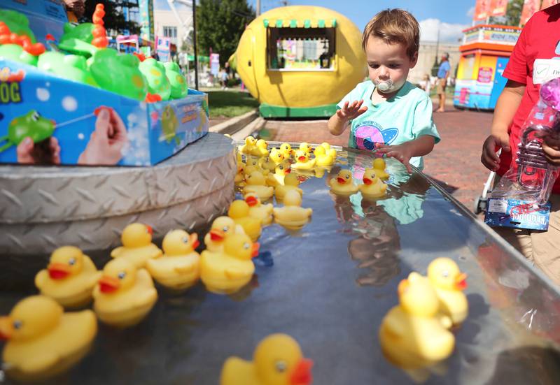 Andy Kuna, 2, from Portland, Ore., tries to pick the lucky duck and win a prize Friday, Aug. 26, 2022, during Corn Fest in downtown DeKalb.