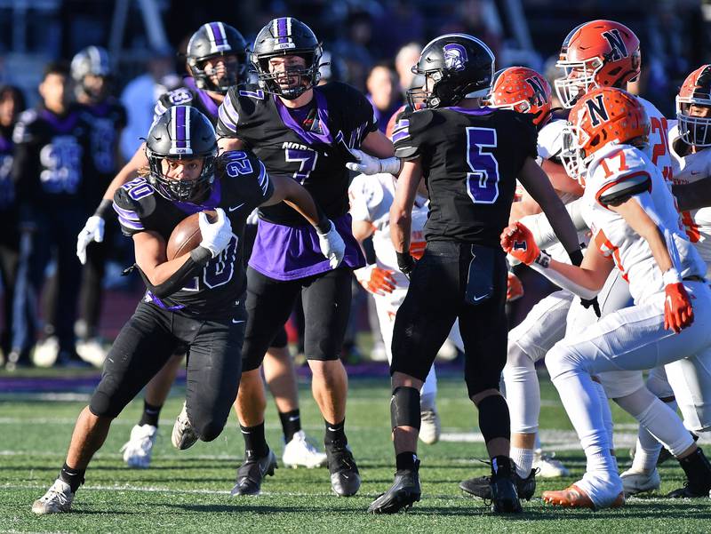 Downers Grove North's Noah Battle (20) breaks through the line for first down yardage during an IHSA Class 7A semifinal game against Normal Community on Nov. 18, 2023 at Downers Grove North High School in Downers Grove .