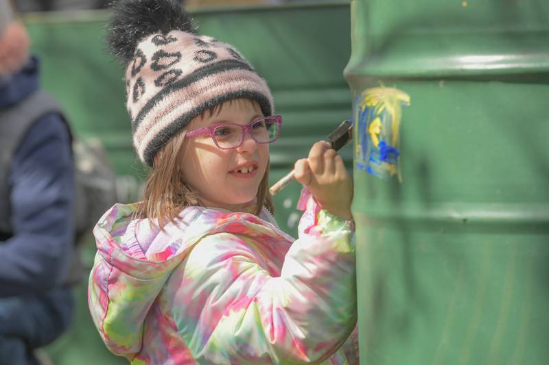 Scarlett Healy, 7 of Geneva paints a garbage can during the Geneva Earth Day Celebration at Peck Farm in Geneva on Saturday, April 20, 2024.