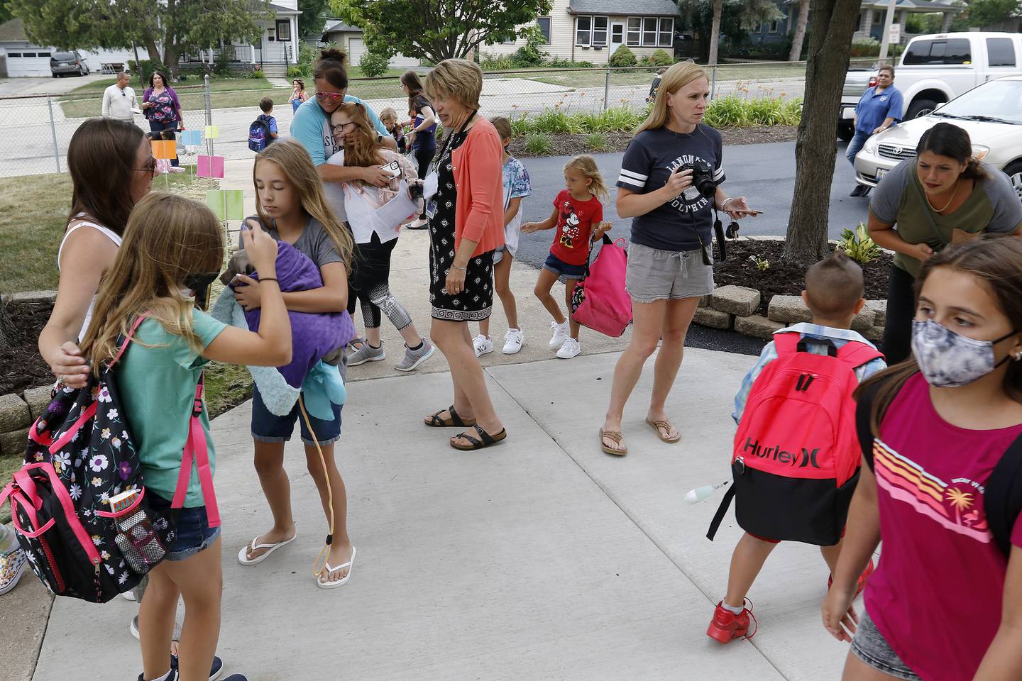 Students are welcomed back to school by staff on their first day back at Landmark Elementary School on Wednesday, July 21, 2021, in McHenry.  The school, which has about 210 students, offers a shortened summer break but extended fall and winter breaks to make the educational process more year-round.