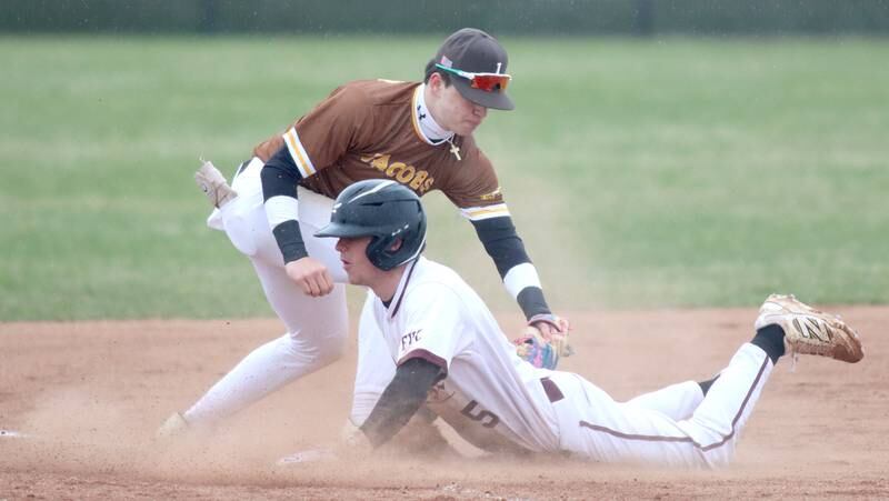 Jacobs’ Ryan Tucker applies a tag as Prairie Ridge’s Brennan Coyle slides safely while advancing to third base on a sacrifice fly in varsity baseball on Wednesday, April 9, 2025, at Prairie Ridge High School in Crystal Lake.