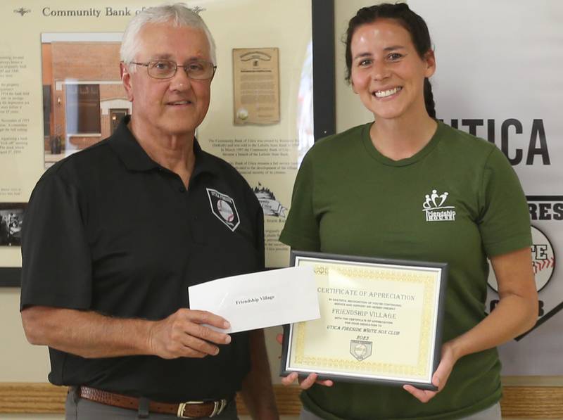 Utica Fireside White Sox Club member Randy Tuftie hands Allison Perez director of employment and outreach services at Friendship Village a donation during the 14th annual Utica Fireside White Sox Club donation presentation on Tuesday, Aug. 15, 2023 at the Utica Township Community Building.