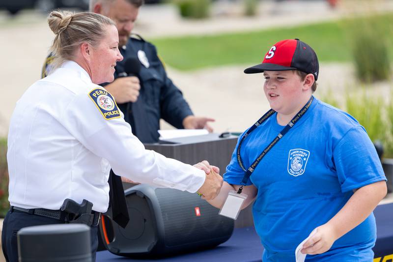 (left to right) Chief Sarah Raymond shakes hand of graduate Levi Petersen at the first annual Juvenile Police Academy graduation ceremony on Friday, July 25, 2025 at the Peru Police Department in Peru.