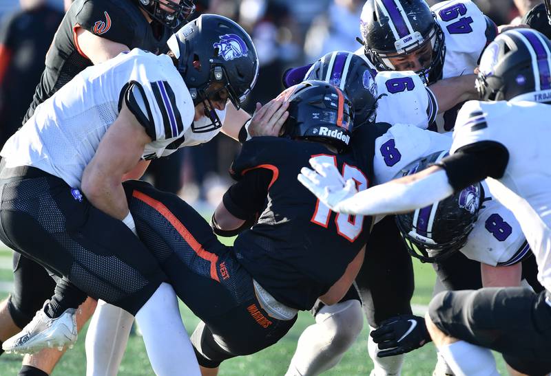 The Downers Grove North defense gang tackles Lincoln-Way West's Joey Campagna (middle) during an IHSA Class 7A quarterfinal game on Nov. 11, 2023 at Lincoln-Way West High School in New Lenox.