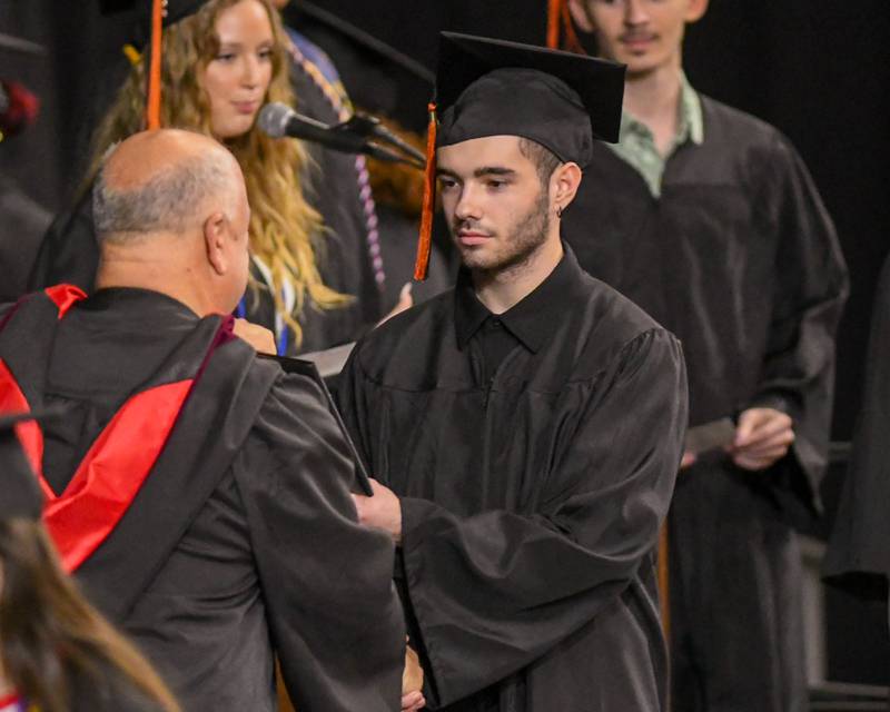 A DeKalb High School graduate accepts his diploma during the graduation ceremony on Saturday May 23, 2026, held at the Convocation Center in DeKalb.
