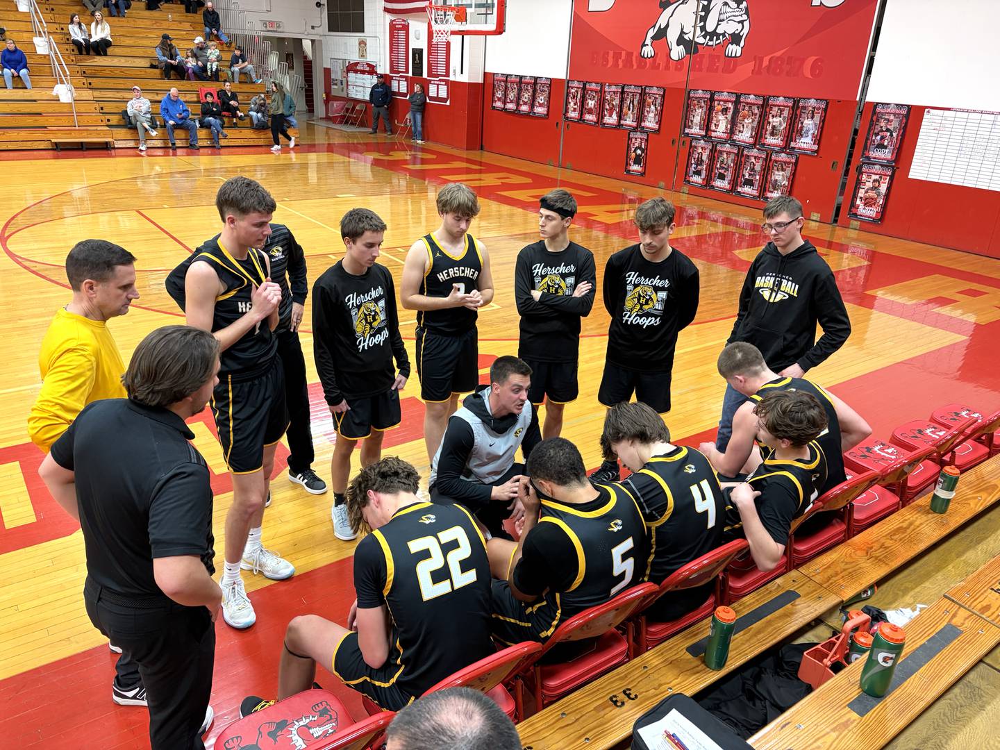 Herscher boys basketball coach Drew Boudreau (center) talks things over with his Tigers during a timeout Tuesday, Feb. 17, 2026, at Streator.