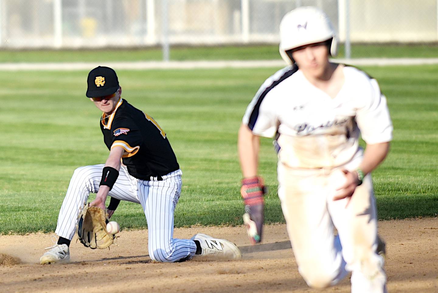 Reed-Custer's Matt Kuban, left, fields a ground ball as Manteno's Brady Hespen heads to third during a game at Manteno Monday, April 14, 2025.
