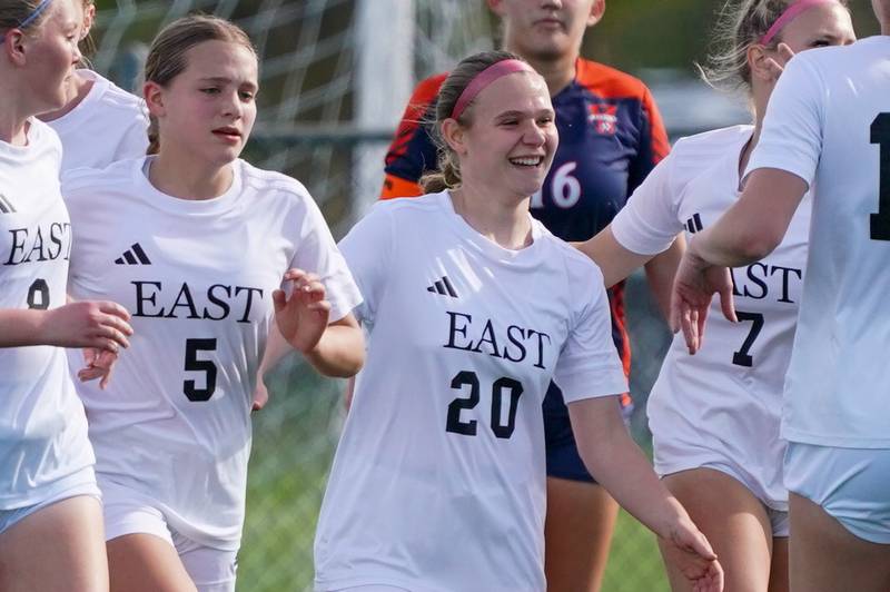 Oswego East's Catie Sloan (20) is greeted by team mates after scoring a goal against Oswego during a soccer match at Oswego High School on Tuesday, April 29, 2025.