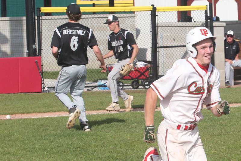 L-P's Braylin Bond runs safe to first base as the ball trickles down the third base line to Kaneland's Preston Popovich while teammate Dylan Borysiewcz runs to assist on Tuesday, May 13, 2025 at Huby Sarver Field at the L-P Athletic Complex in La Salle.