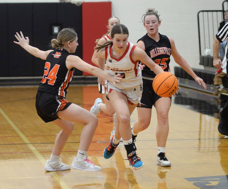 Fulton's Wrenn Coffey (10) dribbles between Milledgeville's Jozlynn Castro (left) and Kendra Hutchinson (right) on Friday, Jan. 24, 2025 at Fulton High School.