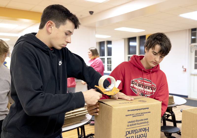 Colton Harms (left) and Carter Hadaway of PLT tape up boxes Wednesday, Nov. 6, 2024, at Sterling High School.