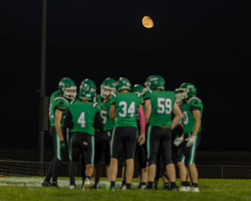 Players of Seneca huddle under crescent moon on Friday, Oct. 10, 2025 at Seneca High School in Seneca.