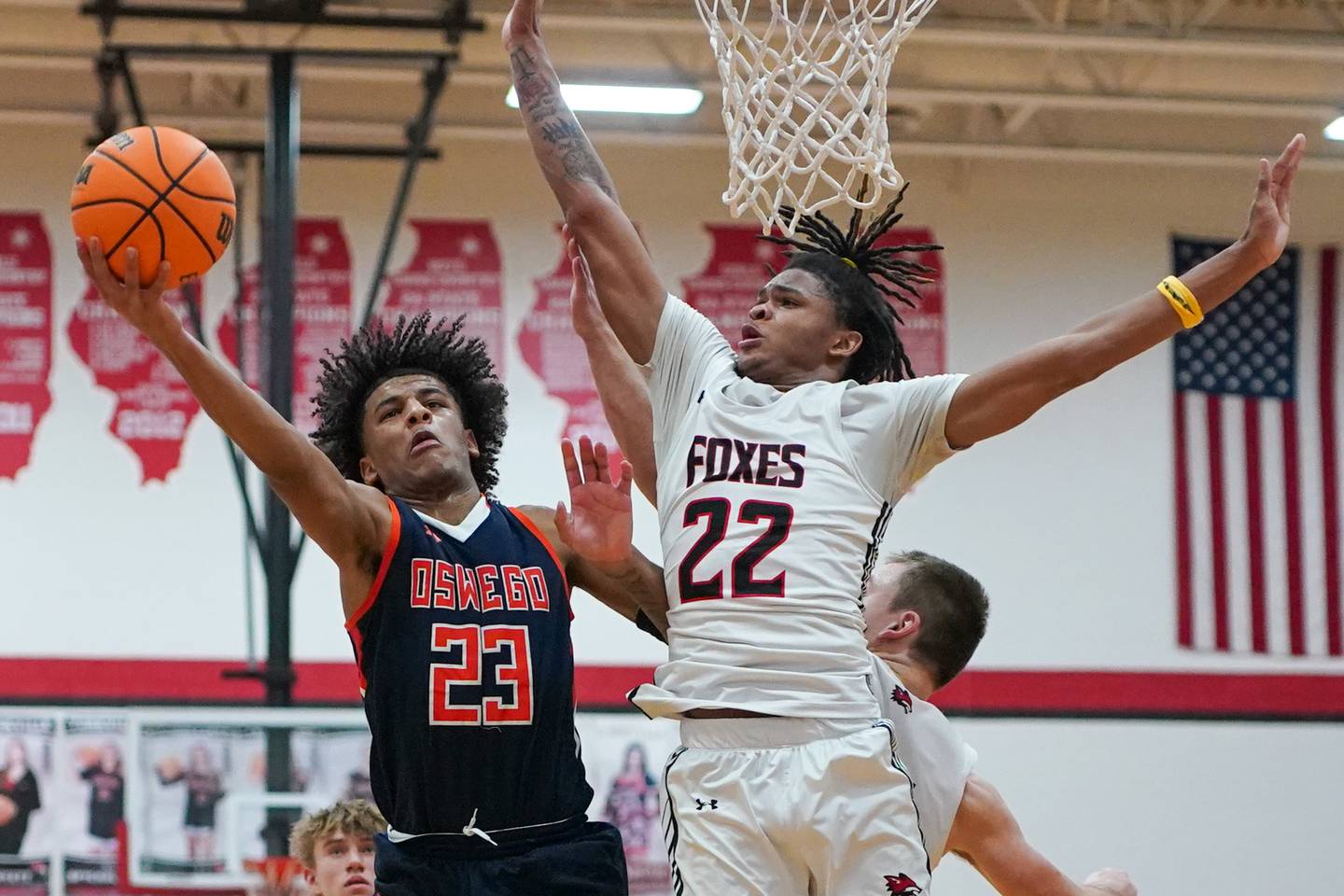 Oswego’s Dasean Patton (23) drives to the basket against Yorkville's Braydon Porter (22) during a hoops for hope basketball game at Yorkville High School on Saturday, Feb. 8, 2025.