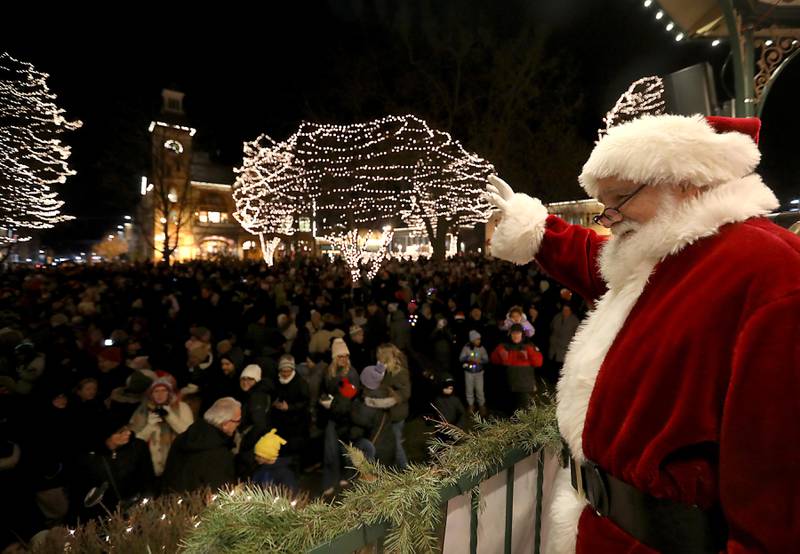 Santa Claus waves to the crowd during the Lighting of the Square on Friday, Nov. 28, 2025, in Woodstock.The annual holiday season event featured brass music, caroling, free doughnuts and cider, food trucks, festive selfie stations and shopping.