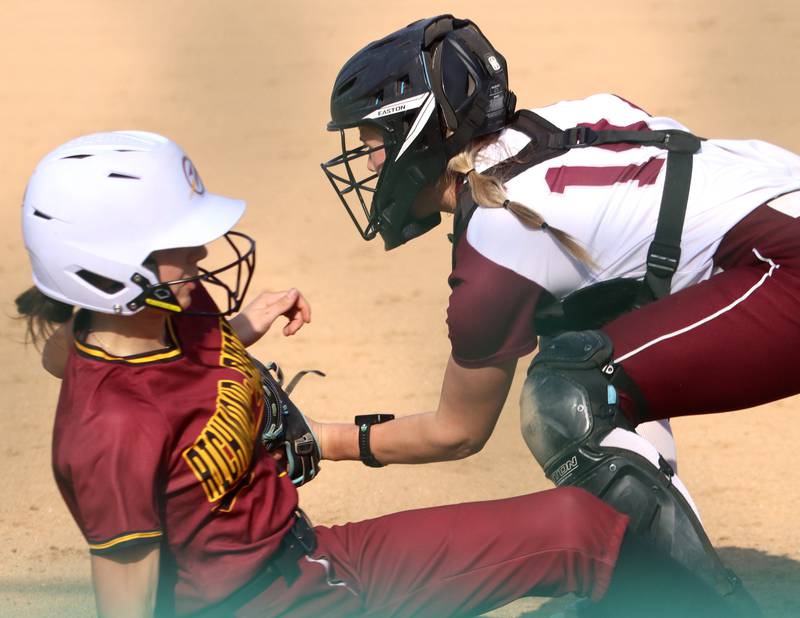 Richmond-Burton’s Jocelyn Hird, front, slides safely into home as  Marengo’s Kylee Jensen fields the throw in varsity softball on Tuesday, April 22, 2025, at Marengo High School in Marengo.