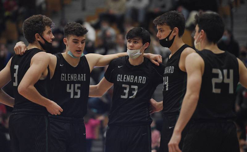 Glenbard West’s Caden Pierce, left, Ryan Renfro, Bobby Durkin, Braden Huff and Paxton Warden, right, get together at the start of the second half against Lyons in the championship game of the Jack Tosh boys basketball tournament at York High School on Friday afternoon, December 31, 2021.