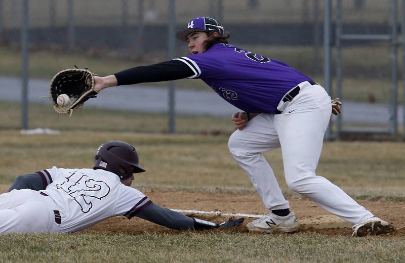 Marengo's Caden Vogt dives back to first base as Hampshire's Dominick Kooistra reaches for the throw during a non-conference baseball game Wednesday, March 30, 2022, between Marengo and Hampshire at Marengo High School.