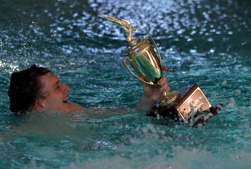 Drew Watson of Cary-Grove co-op celebrates with the trophy after his team cruised to victory at the Fox Valley Conference Swimming Championships at Woodstock North High School Saturday.