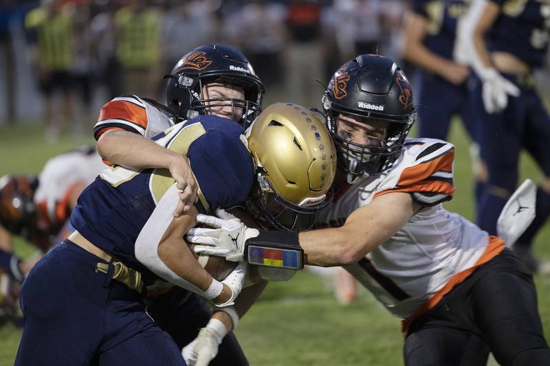 Polo’s Mercer Mumford is tackled by Milledgeville’s Caleb Sarber (left) and Evan Schneck Friday, Sept. 19, 2025.