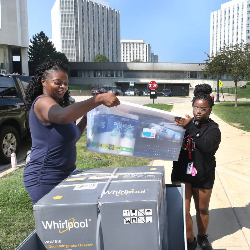 Northern Illinois University freshman Serenity Stewart, (right) from Plainfield, gets a hand from her mom Michelle Gillespie as they load a cart with things to move into her room Wednesday, Aug. 23, 2023, during move-in day in front of the Fanny Ruth Patterson Complex at NIU in DeKalb.