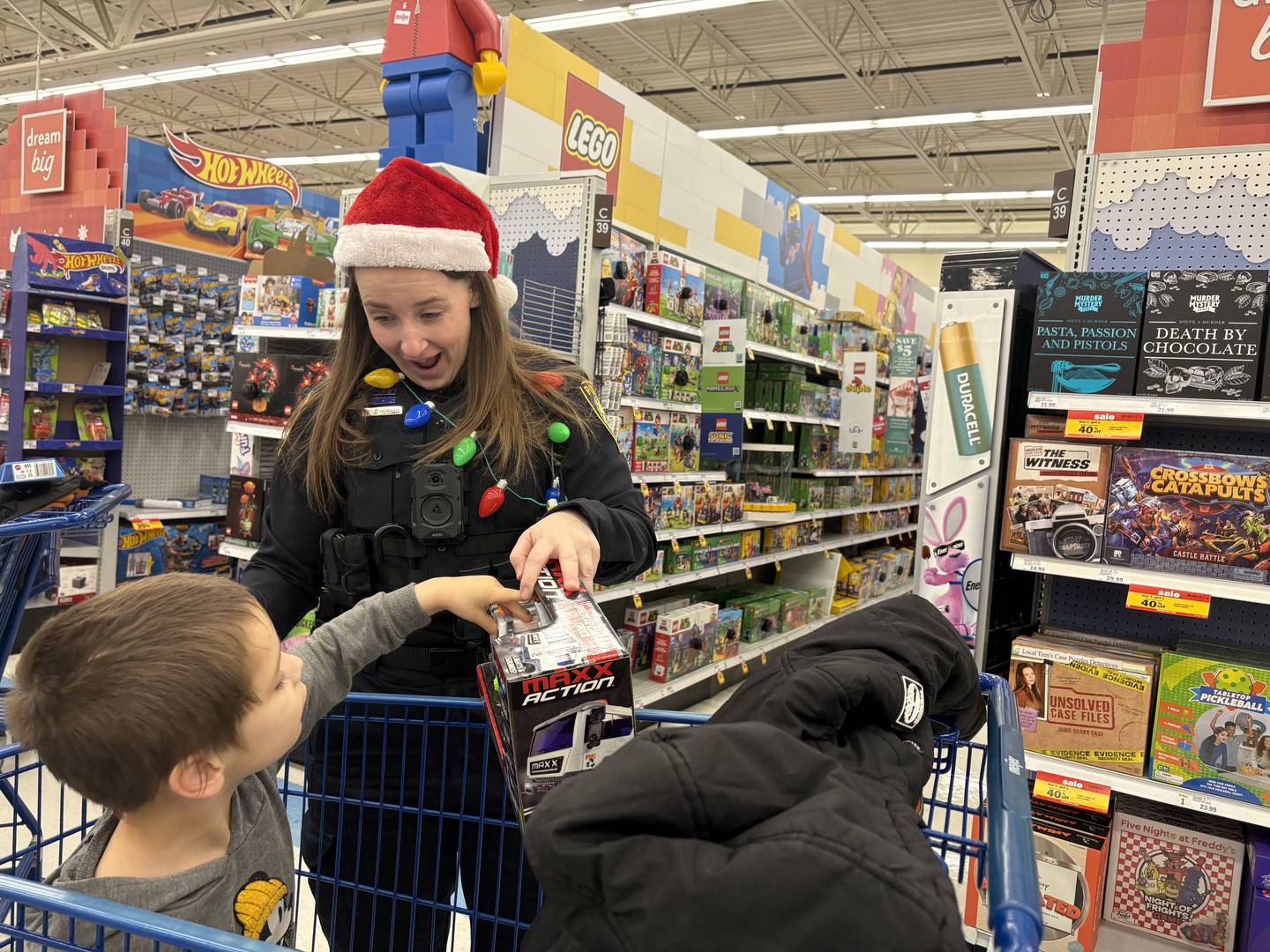 Officer Ashley O'Herron of the McHenry Police Department shows a toy to Nicholas Pacheco, 5, of McHenry during Shop with a Cop Dec. 8, 2024 in McHenry.