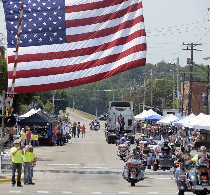 A giant American flag greets the riders Saturday, June 17, 2023, on Main Street in Marseilles as the Illinois Motorcycle Freedom Run goes through town on the way to the Middle East Conflicts Wall.