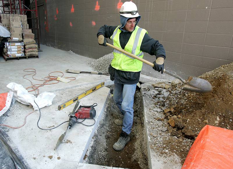Sherman Mechanical employee Steve Matusek of Crystal Lake clears a trench Monday for a plumbing line in the new addition of the Sage YMCA in Crystal Lake.