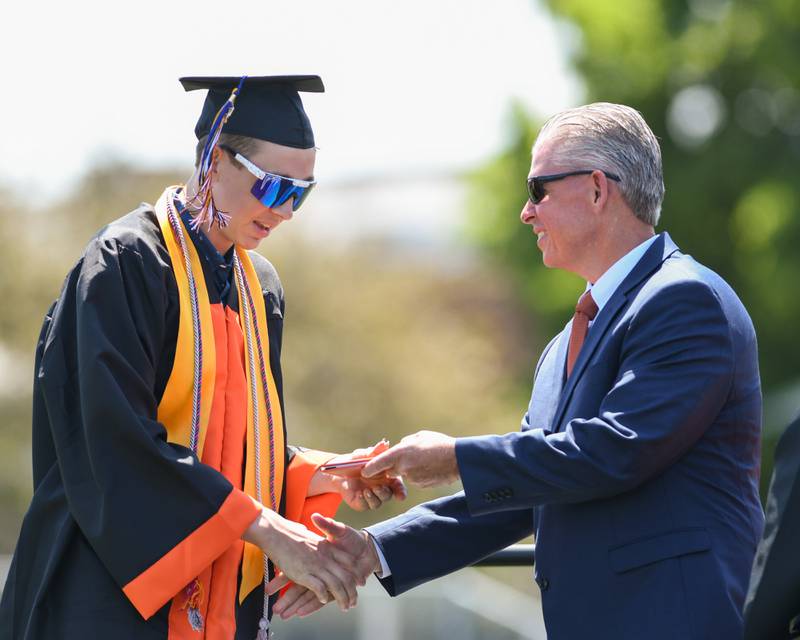 A Sandwich High School graduate receives his diploma on Sunday May 21, 2023 at the high school’s football field.