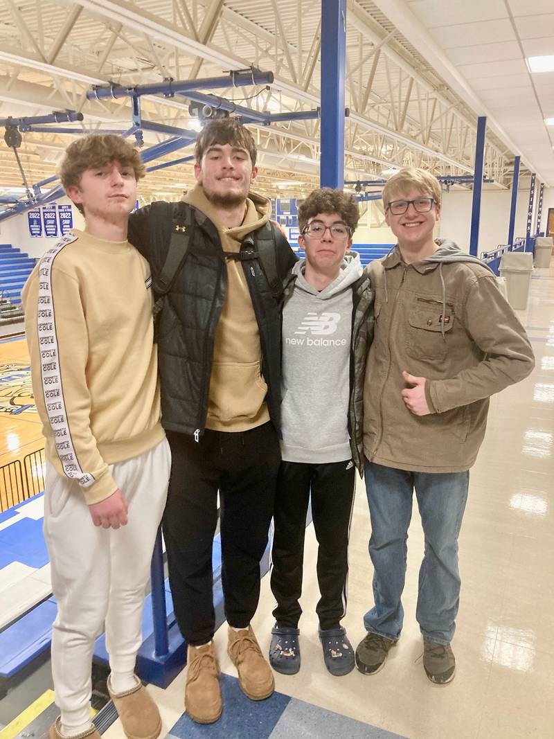 Former Princeton High School All-Stater Grady Thompson, now a sophomore at the University of Dubuque, greets members of the Princeton Christian Academy high school team, (from left to right) Julian Mucha, Santiago Slevin and Trusin Crew, after the Spartans' home game on Saturday.