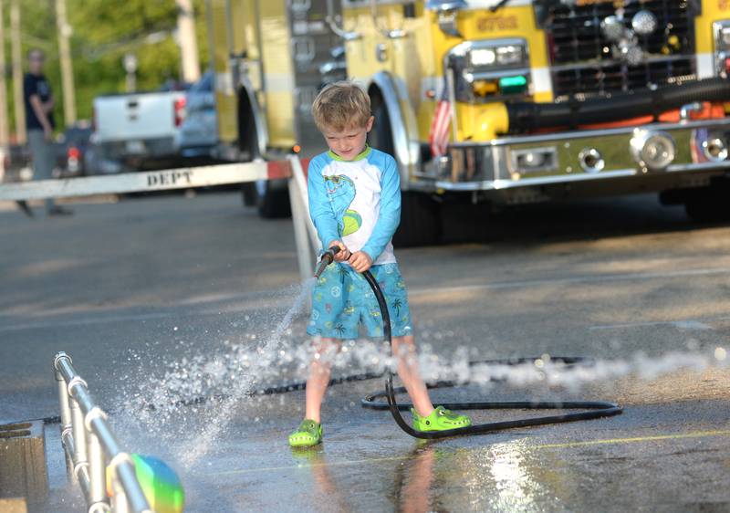 Elijah Ward, 5, sprays water at a plastic ball  during the kids' water fight at Let Freedom Ring on Monday. The event was organized by the Mt. Morris Fire Department.