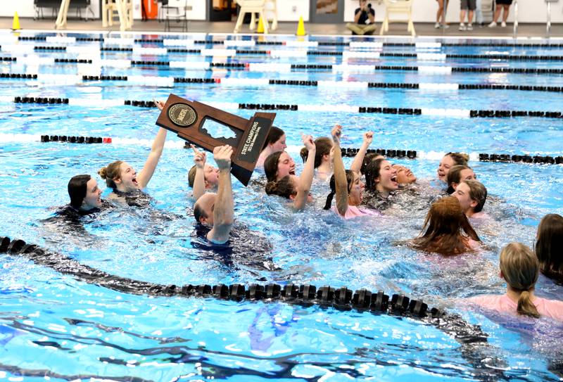 Rosary swimmers celebrate their first place state trophy in the IHSA Girls State Swimming and Diving Championships at the FMC Natatorium in Westmont on Saturday, Nov. 11, 2023.