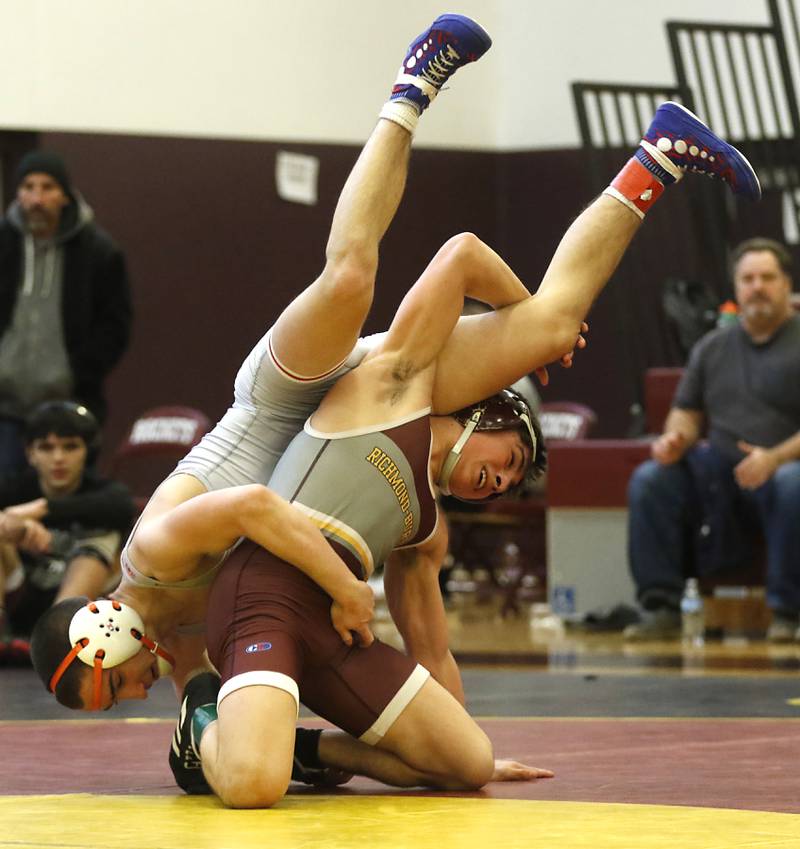 Marian Central’s Kaden Harman hangs onto Richmond-Burton’s Emmett Nelsen as they compete in the 126-pound championship wrestling match in the IHSA 1A Richmond-Burton Wrestling Regional Thursday, Jan. 19, 2023, at Richmond-Burton High School in Richmond.