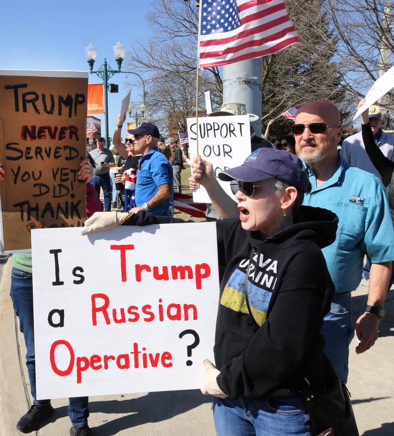 Sylvia Dunton (left) and her husband Bruce, US Air Force veterans from Sycamore, take part in a protest Friday, March 14, 2025, on the corner of State and Main Street in Sycamore, to voice their displeasure with President Donald Trump. The group was protesting recent cuts by the Trump administration to the Department of Veterans Affairs.