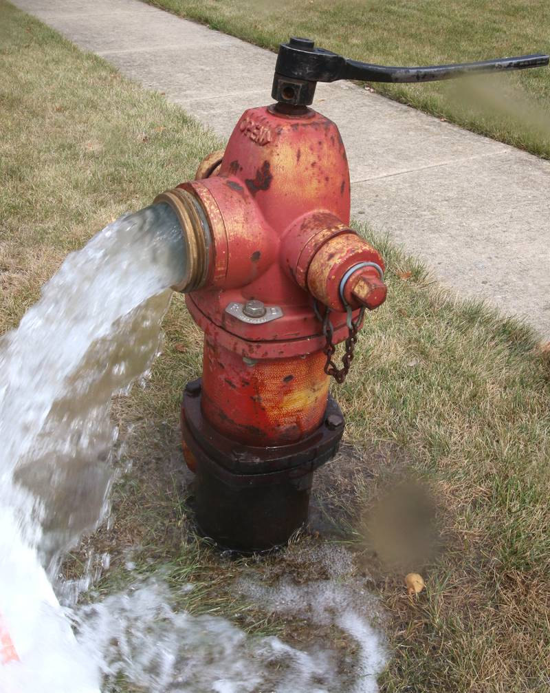 A fire hydrant is flushed on Briggs Street in Sycamore.