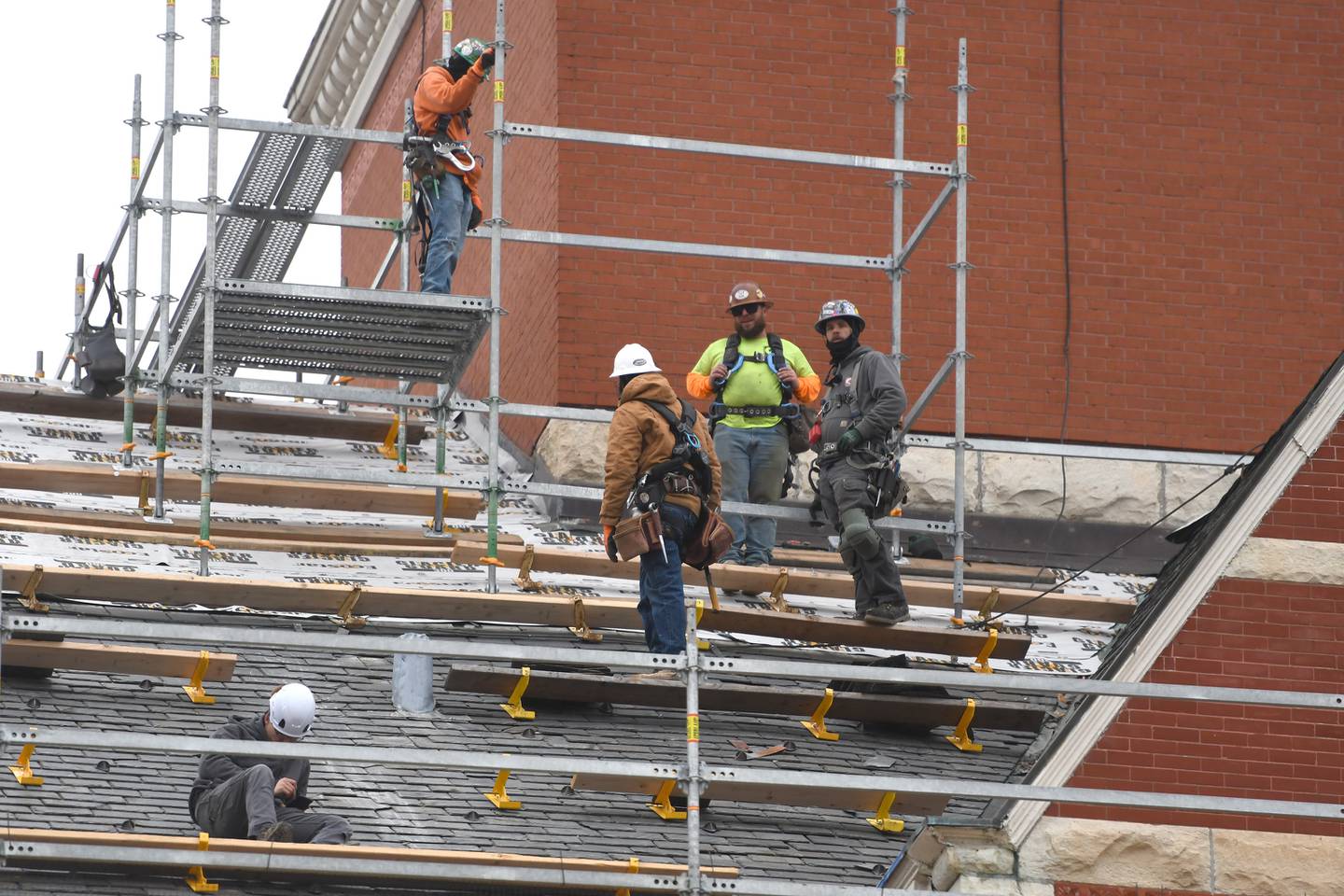 Workers from Sterling Commercial Roofing stand on the roof of the historic Ogle County Courthouse as they remove slate shingles from the 134-year-old structure on Wednesday, Nov. 19, 2025.