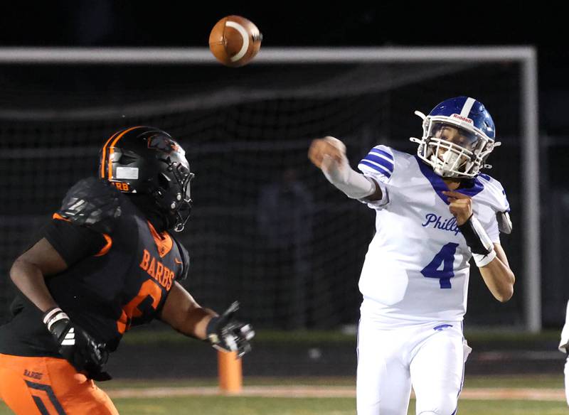 Phillips' Cordell Lee throws a pass over DeKalb's Travis Moore Friday, Sept. 5, 2025, during their game at DeKalb High School.