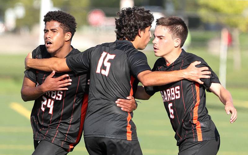 DeKalb's Josiah Antimo, (left) Aaron Tierney and Landon Weishaar (right) celebrate Antimo's goal during their game Thursday, Aug. 25, 2022, in the Barb Cup at the Northern Illinois University Outdoor Recreation Sports Complex.