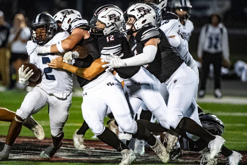 Oswego East's Jasiah Watson is brought down by Plainfield Norths defense during a game on Friday Sept. 12, 2025 at Plainfield North High School in Plainfield