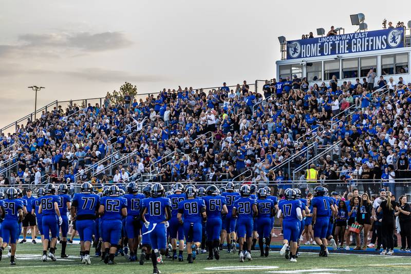 Lincoln-Way East fans rise to cheer on Jonas Williams and the team after Williams broke the state passing touchdown record during a varsity football game against Metea Valley at Lincoln-Way East on Oct. 3, 2025.