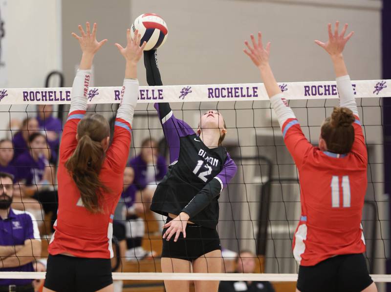 Dixon’s Izzy Queckboerner spikes the ball between two Ottawa blockers Tuesday, Oct. 28, 2025, during their Class 3A regional semifinal match at Rochelle High School.