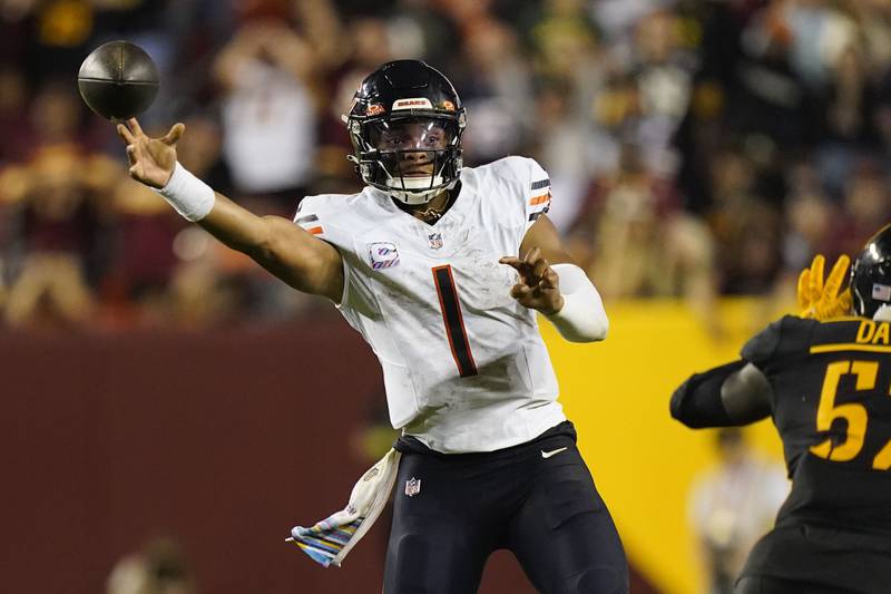 Chicago Bears quarterback Justin Fields passes around Washington defensive end Khalid Kareem during the second half, Thursday, Oct. 5, 2023, in Landover, Md.