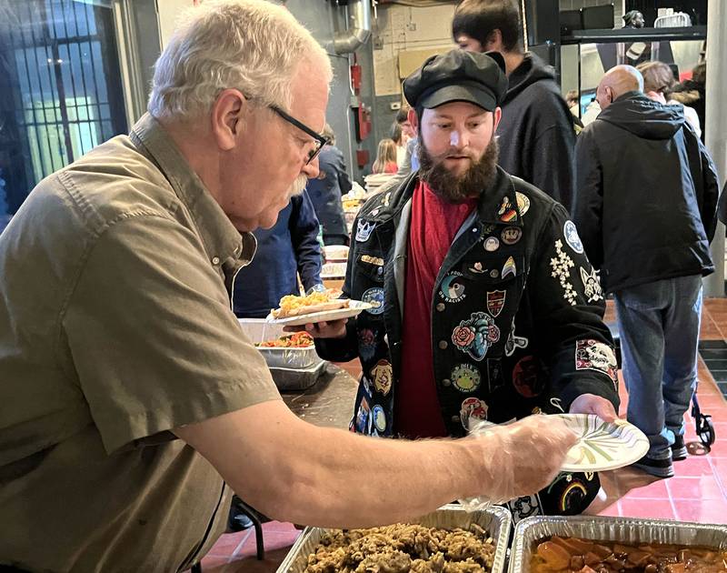 Sata Prescott, (right) from DeKalb goes through the serving line Wednesday, Nov. 26, 2025, during A World of Thanks, Community Thanksgiving hosted by DeKalb Mutual Aid at the McCabe’s building in DeKalb.