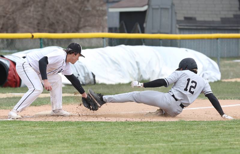DeKalb's Jack Keck is tagged on the foot by Kaneland's Collin Miller as he tries to steal third during their game Friday, April 15, 2022, at Kaneland High School in Maple Park. Keck was called safe on the play.