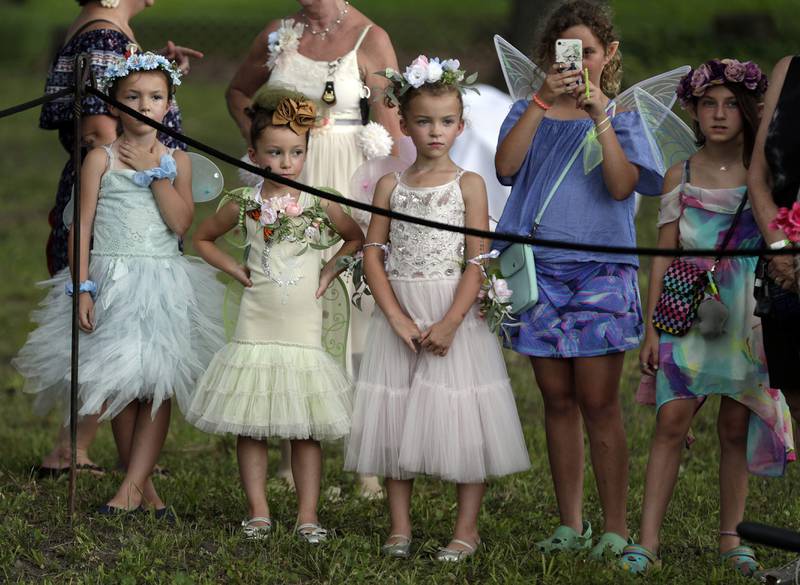 Young girls dressed as Faeries wait for The Swords of Valour sword-fighting group to perform during the World of Faeries Festival Saturday August 6, 2022 at Vasa Park in South Elgin.