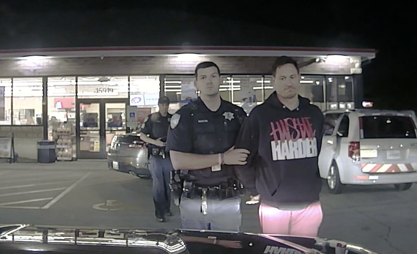 Plainfield Police Officer Ryley Martin takes former Will County sheriff's deputy Ross Ricobene to the front of his squad vehicle for a pat-down search on May 13, 2022 in Plainfield.