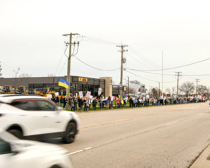 Community members line Ogden Ave. outside the Tesla dealership on Saturday April 5, 2025, in Lisle during the Hands Off Demonstration.