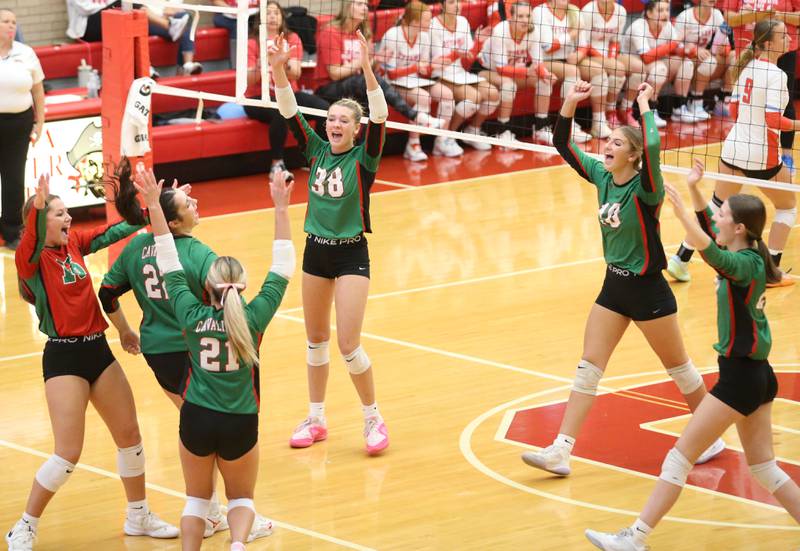 Members of the L-P volleyball team celebrate after scoring a point against Ottawa on Thursday, Oct. 17, 2024 in Kingman Gym at Ottawa High School.