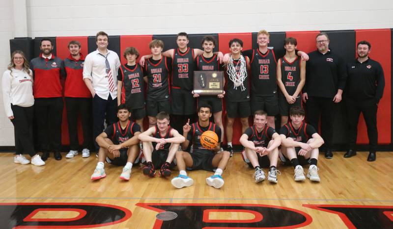 Members of the Indian Creek boys basketball team pose with the Class 1A Sectional plaque after defeating Marquette on Friday, March 6, 2026 at Amboy High School.