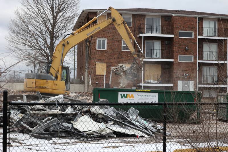 An excavator puts debris in a dumpster after a portion of the apartments at 1024 W. Hillcrest Drive in DeKalb was torn down earlier in the day. The structure was ravaged by fire on Dec. 22, 2024, and condemned.